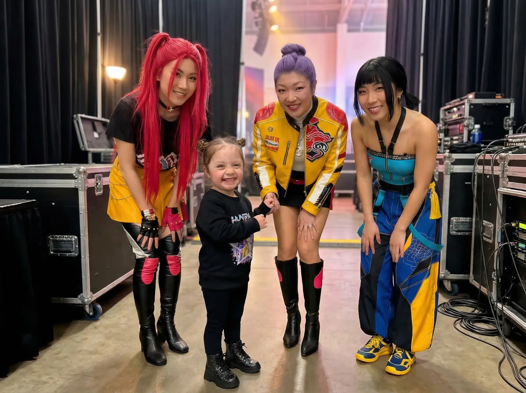 A child meeting a colourful group of performers backstage