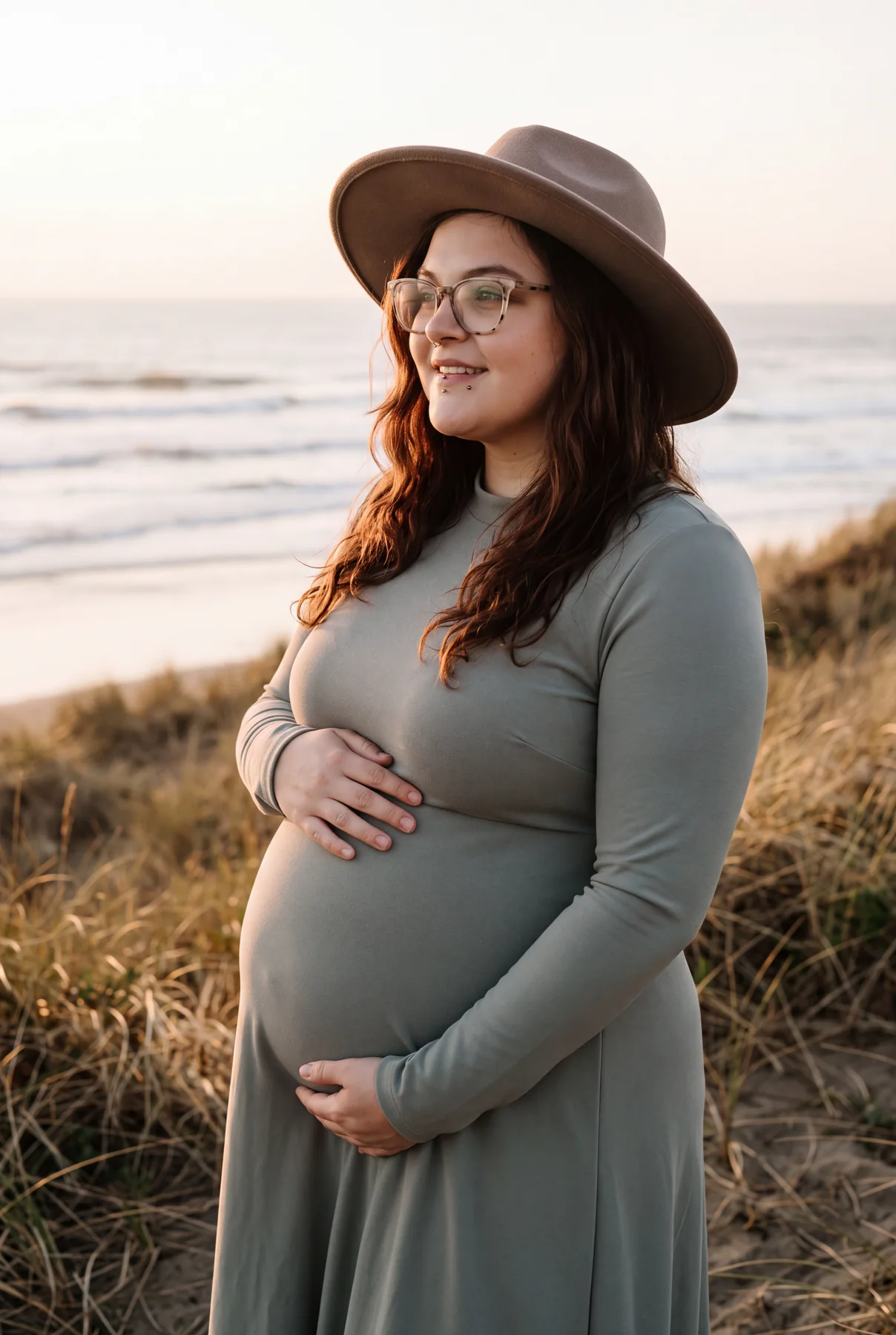 A close maternity portrait among softly lit coastal dunes